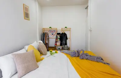 a bedroom with a bed with yellow and white pillows at Ratchada Retreat Bespoke Urban Villa 3 in Bangkok