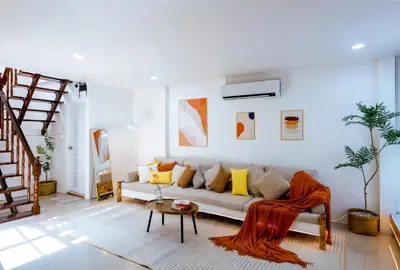 a living room with a couch and a staircase at Ratchada Retreat Bespoke Urban Villa 3 in Bangkok