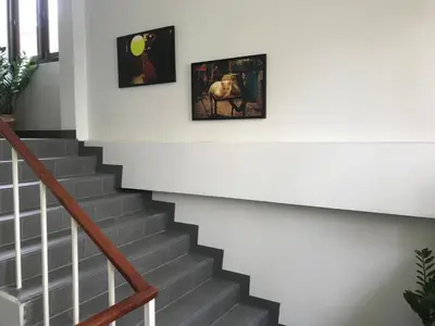 a staircase with two pictures on the wall at Manoo House H in Makkasan