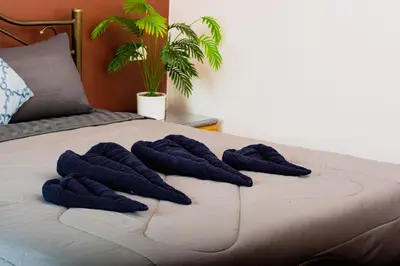 a bed with three blue towels on it at Hostel Bangkok BM B&B in Bangkok