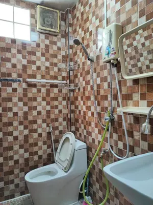 a bathroom with a shower with a toilet and a sink at Mansion 24 in Bangkok