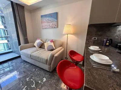 a living room with a couch and red chairs at Willow Whisper Nest in Bangkok