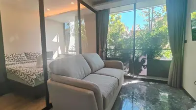 a living room with a couch and a large window at Willow Whisper Nest in Bangkok