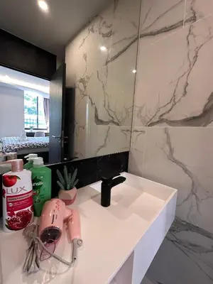 a bathroom with a white sink and a mirror at Willow Whisper Nest in Bangkok