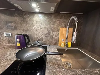 a kitchen with a pan on a stove with a sink at Willow Whisper Nest in Bangkok