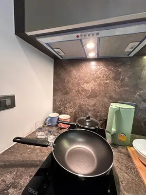 a kitchen with a stove with two pans on it at Willow Whisper Nest in Bangkok