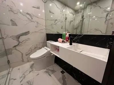 a bathroom with a toilet and a sink and a mirror at Willow Whisper Nest in Bangkok