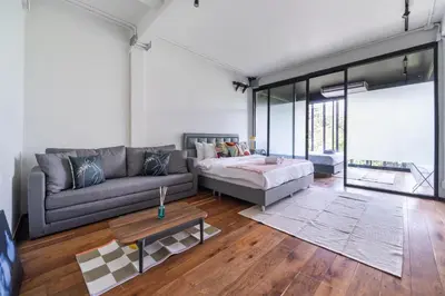 a living room with a couch and a bed at MIQ Ekkamai2 3BR Designer home Oval Bathtub 15pax in Bangkok