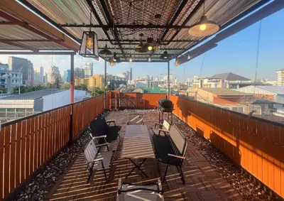 a patio with a table and chairs on a balcony at 4 Bedroom House with Beautiful Rooftop near BTS Ekkamai in Bangkok