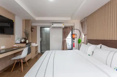 a hotel room with a large bed and a kitchen at โรงแรมเซเว่นรัชดา S7VEN RATCHADA in Bangkok