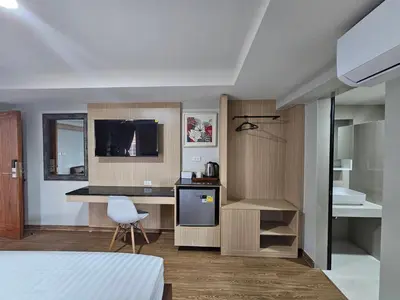 a room with a bed and a kitchen with a television at โรงแรมเซเว่นรัชดา S7VEN RATCHADA in Bangkok