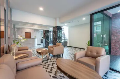 a waiting room with couches and chairs and a table at โรงแรมเซเว่นรัชดา S7VEN RATCHADA in Bangkok