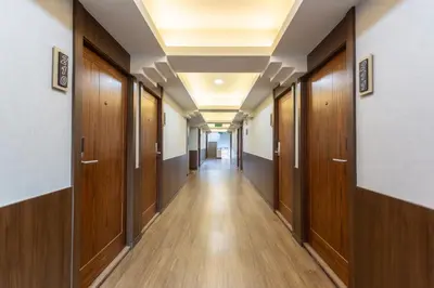 a corridor in a hospital with wooden doors at โรงแรมเซเว่นรัชดา S7VEN RATCHADA in Bangkok