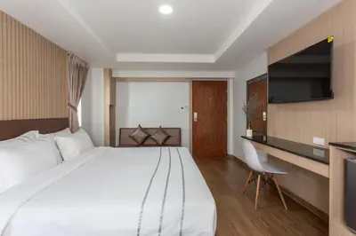 a hotel room with a large bed and a desk at โรงแรมเซเว่นรัชดา S7VEN RATCHADA in Bangkok