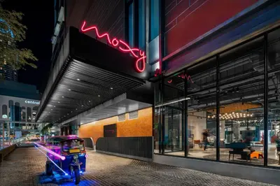 a person riding a motorcycle in front of a store at Moxy Bangkok Ratchaprasong by Marriott in Bangkok