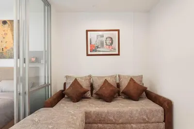 a couch with pillows sitting in a room at Fully Furnished Studio Apt. 110 in Bangkok