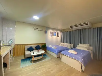 a hotel room with two beds and a couch at PTJ Style Condotel คอนโดเมืองทอง P1 in Ban Song Hong