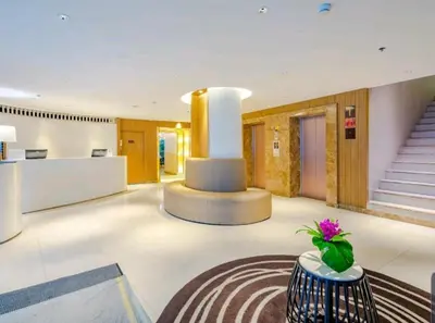 a lobby with a staircase and a vase of flowers on a table at Citrus Sukhumvit 11 by Compass Hospitality in Bangkok