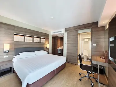 a bedroom with a bed and a desk and a chair at Citrus Sukhumvit 11 by Compass Hospitality in Bangkok
