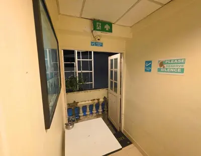 a hallway in a hospital with a sign on the wall at Greenhouse Bangkok Khaosan in Bangkok