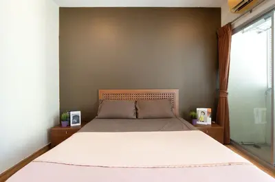 a bedroom with a bed and a window at 181 Ekkamai Apartment in Bangkok