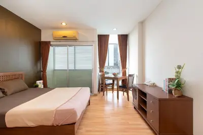 a bedroom with a bed and a desk and a table at 181 Ekkamai Apartment in Bangkok