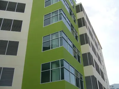 a tall green and white building with many windows at 181 Ekkamai Apartment in Bangkok