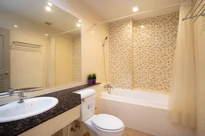 a bathroom with a sink and a toilet and a bath tub at 181 Ekkamai Apartment in Bangkok