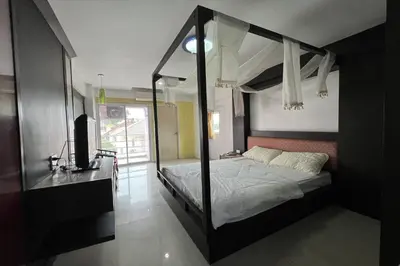 a bedroom with a canopy bed and a television at Phongsathon Mansion in Bangkok