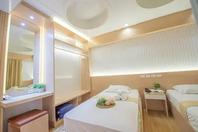 a small room with two beds and a mirror at Thrive Hotel in Bangkok