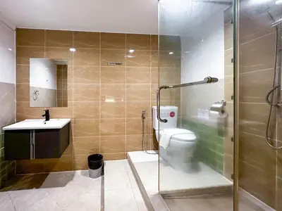 a bathroom with a shower and a toilet and a sink at Thrive Hotel in Bangkok