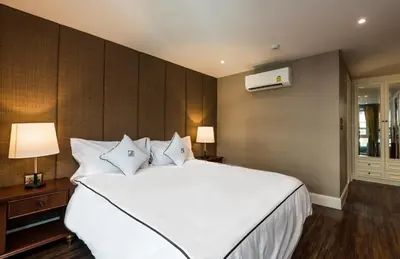a bedroom with a large white bed with white pillows at The Elite @ Thong Lor 25 in Bangkok