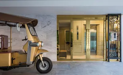 a yellow scooter parked in front of a building at The Elite @ Thong Lor 25 in Bangkok