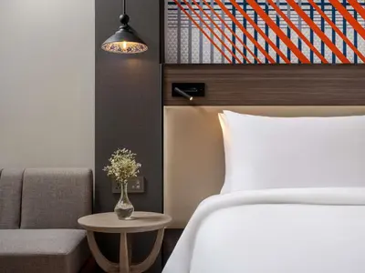a bedroom with a bed and a table and a chair at Mercure Bangkok Surawong in Bangkok