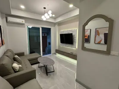 a living room with a couch and a mirror at Pipp Residence in Bangkok