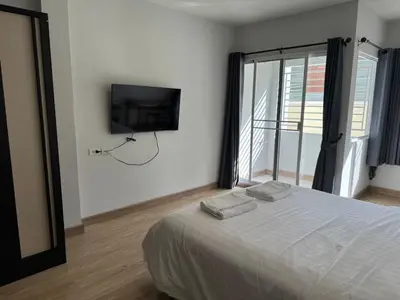 a bedroom with a bed and a tv on the wall at Pipp Residence in Bangkok