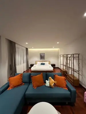 a blue couch in a living room with a bed at Bunya House near BTS Asok, Terminal21 Free BF in Bangkok