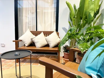 a bench with pillows and plants in a room at Bunya House near BTS Asok, Terminal21 Free BF in Bangkok