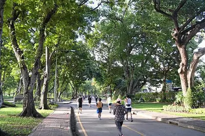 a group of people walking down a street with trees at MIQ_5br/Silom Bts,Mrt/Wifi 1000MB/Jacuzzi/16pax in Bangkok