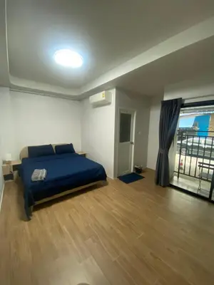 a bedroom with a blue bed and a large window at N place Huai Khwang in Bangkok