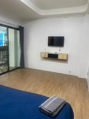 a room with a bed and a flat screen tv on a wall at N place Huai Khwang in Bangkok