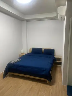 a bedroom with a bed with a blue bedspread at N place Huai Khwang in Bangkok