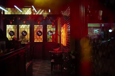a dark room with a bar with red lights at Belivin99 Residence Chinatown in Bangkok