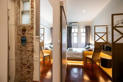 a hotel room with a bedroom and a room with a bed at Belivin99 Residence Chinatown in Bangkok