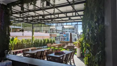 an outdoor patio with wooden tables and chairs at Urban Jungle Social in Bangkok