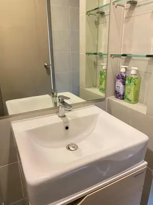 a white sink in a bathroom with a mirror at Ideo O2 BTS Bangna in Bangkok