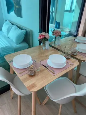 a wooden table with white plates on top of it at Ideo O2 BTS Bangna in Bangkok