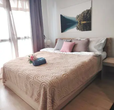 a bedroom with a large bed with flowers on it at Ideo O2 BTS Bangna in Bangkok
