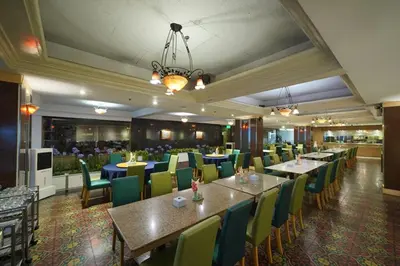 a dining room with tables and chairs in a restaurant at Riverside Bangkok Hotel in Bangkok