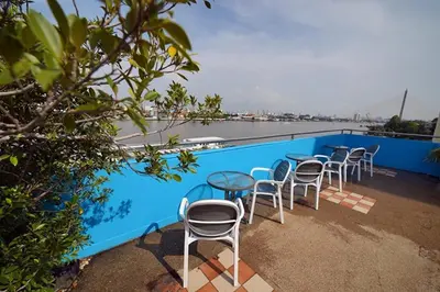 a row of tables and chairs next to a swimming pool at Riverside Bangkok Hotel in Bangkok